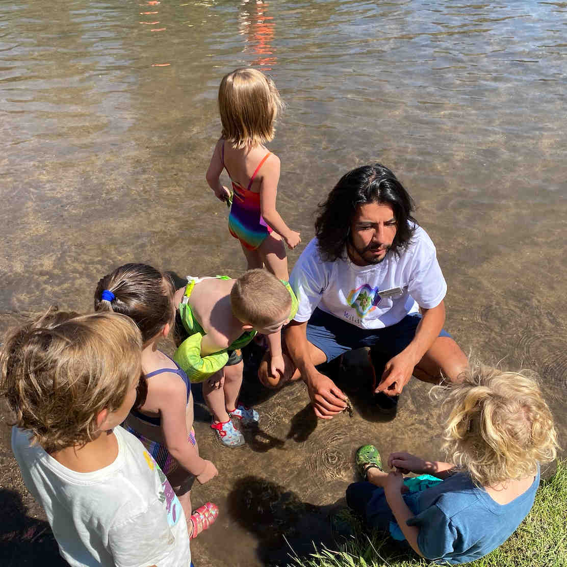 Teacher with kids at river at summer camp